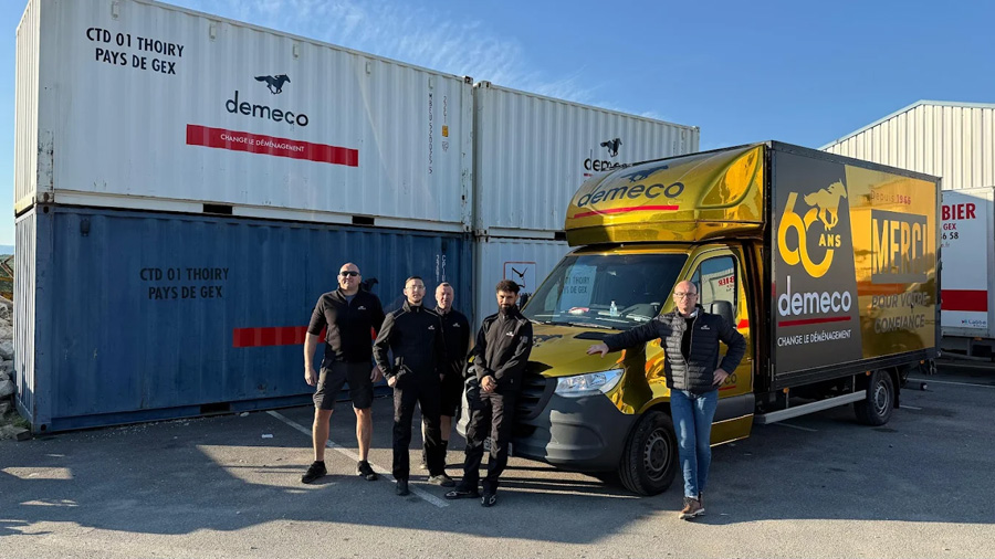 Camion de déménagement Demeco devant des container au port